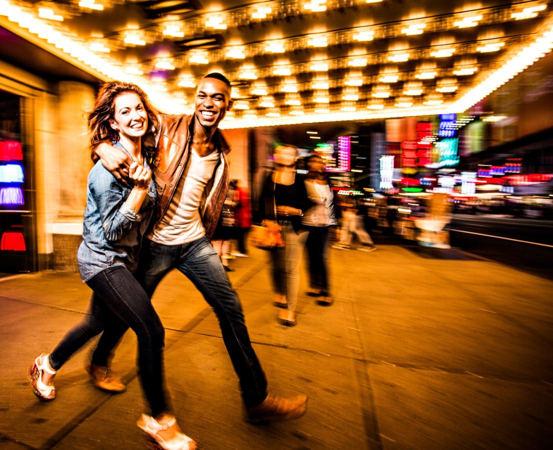 Couple having fun at night on Broadway, New York City